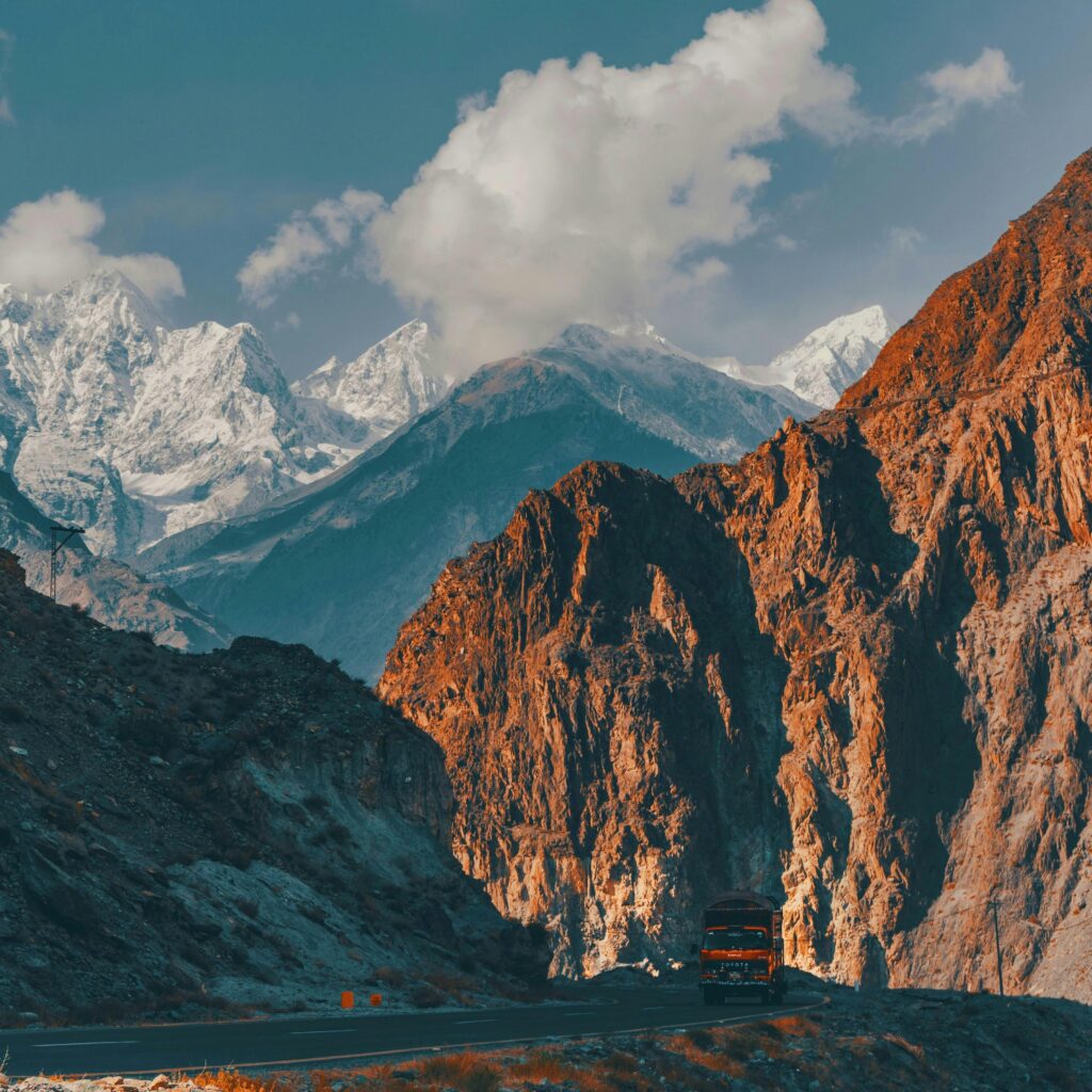 Scenic view of a mountain road with a truck in the Karakoram Range, Pakistan.