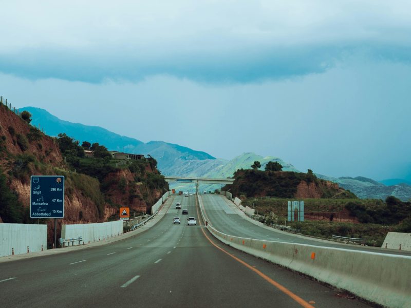 Picturesque highway road with distant mountains and cloudy sky in Pakistan.