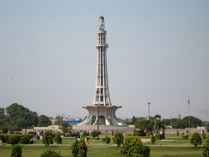 Stunning daytime capture of Minar-e-Pakistan surrounded by lush greenery in Lahore.